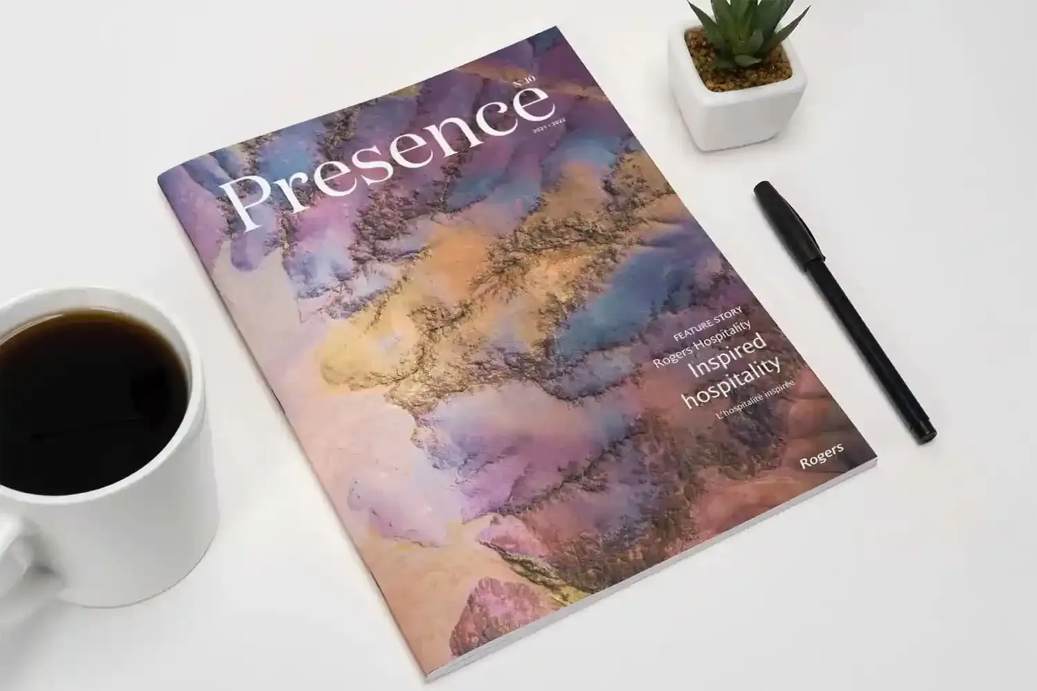 Printed issues of Presence Magazine laid out on a light surface