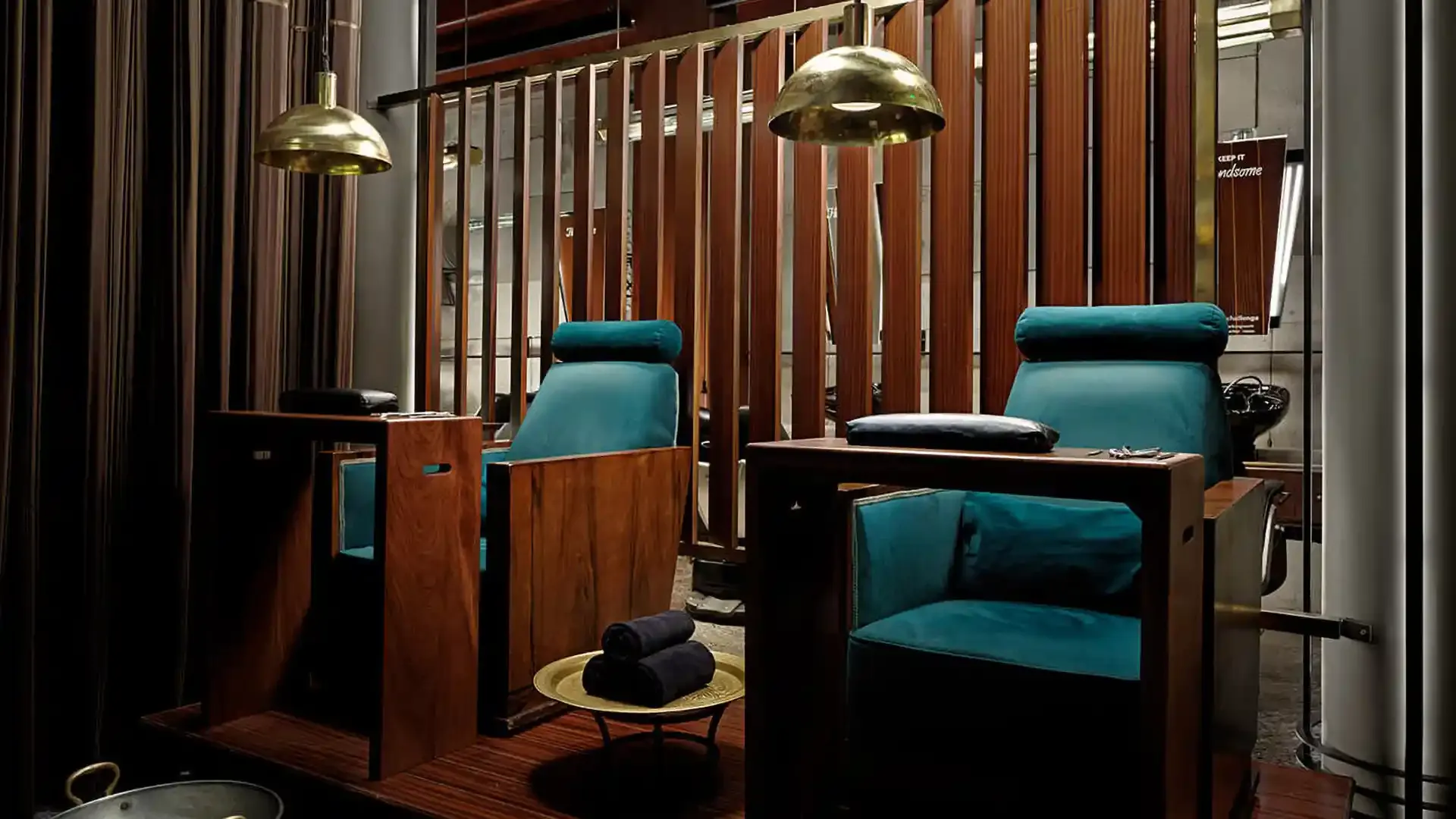 Teal pedicure chairs in a wood-panelled grooming salon.